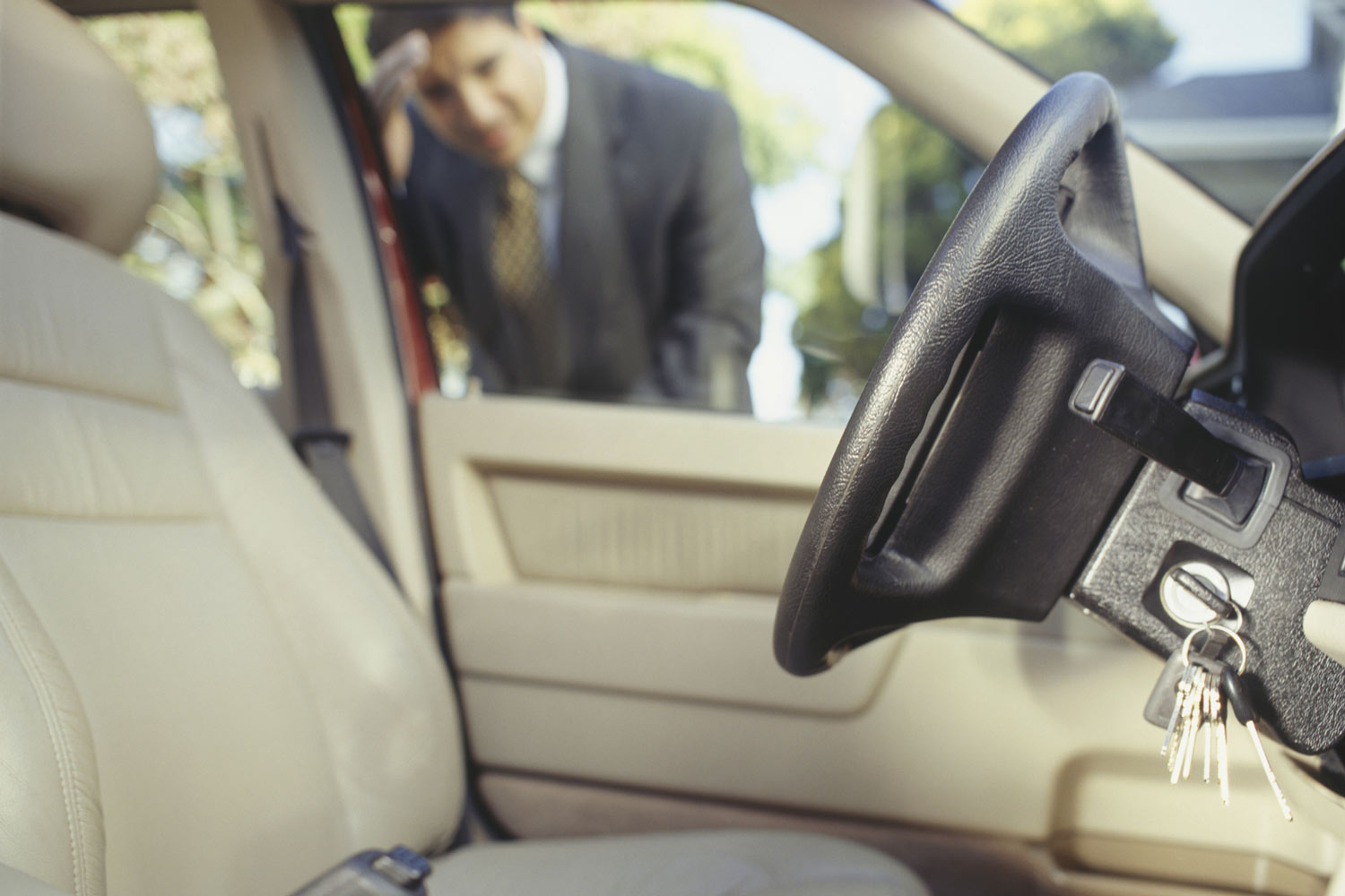 A person looking through window at keys locked in car.