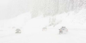 Three cars driving in heavy snow