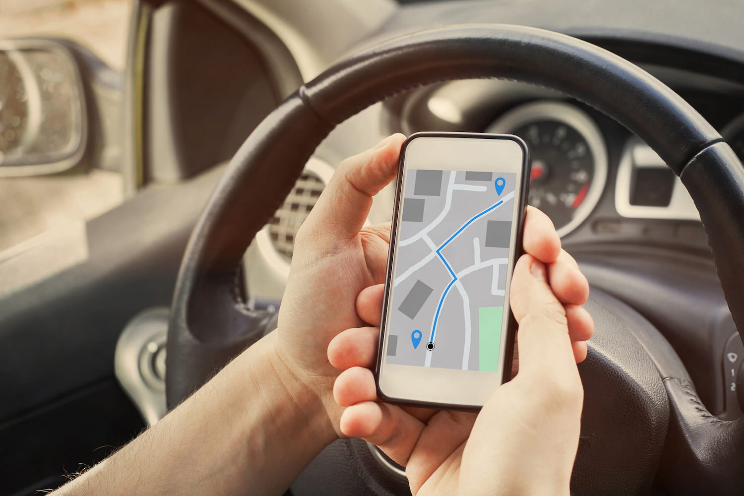 Driver using direction navigation on GPS map on the screen of mobile phone.
