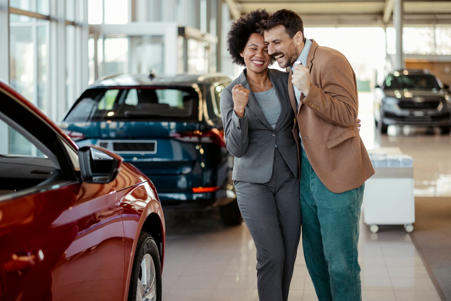 Couple celebrating near new family auto.