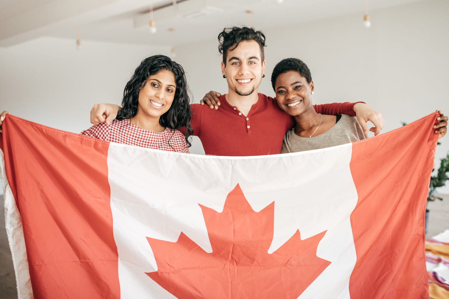 Smiling individuals holding a flag.