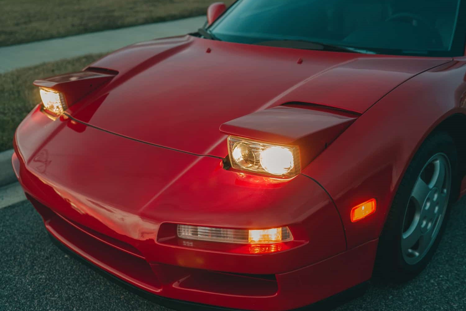 Closeup of a red car with pop up headlight
