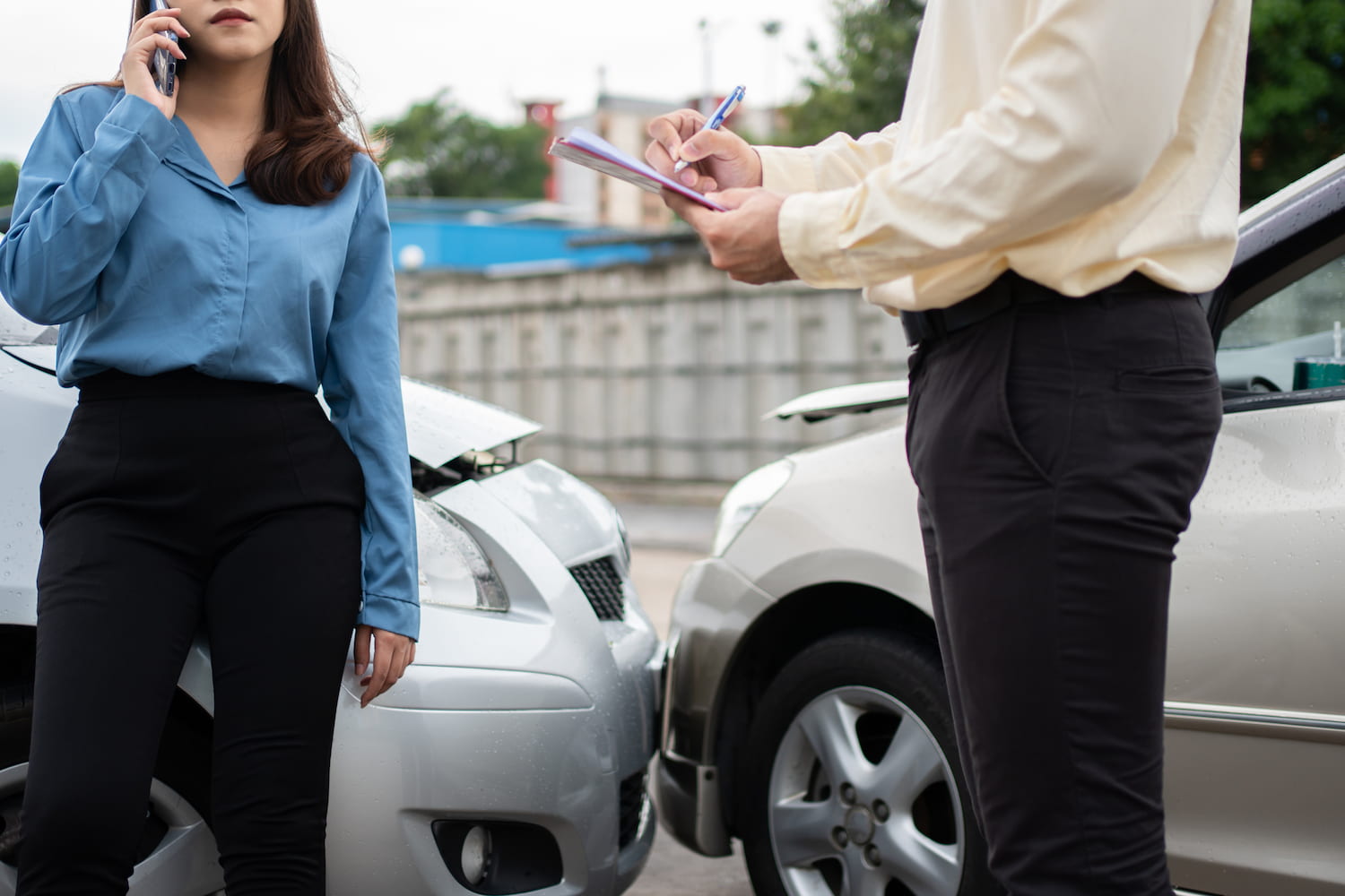 A person discusses damaged car with an agent and reviews report after an accident.