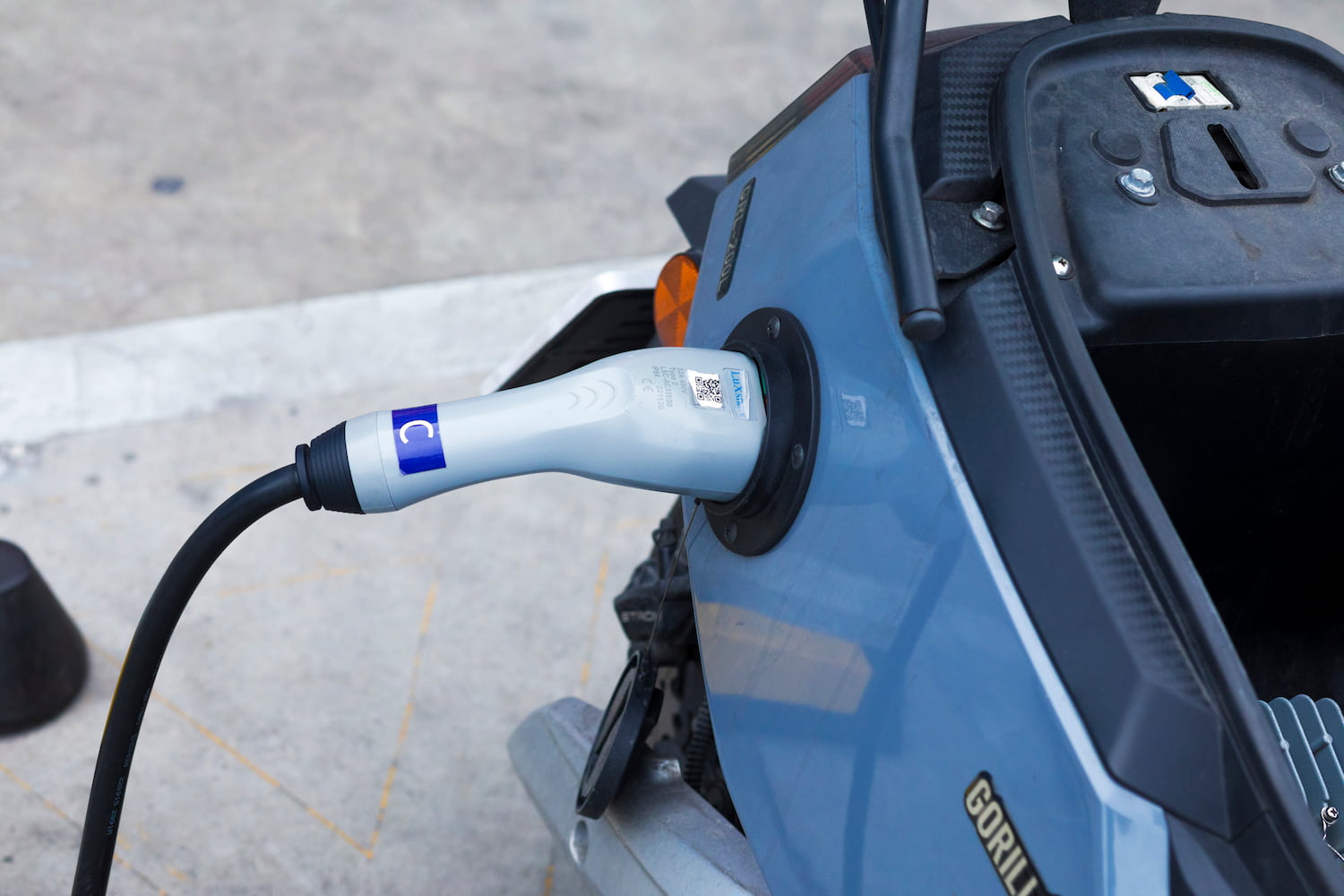 Electric motorcycle plugged to ev charger station.