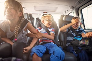 Kids laughing in the back seat of a car