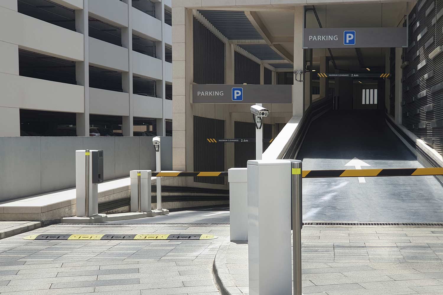 Entrance to Underground Parking: Barrier with Camera, Parking Sign, and Height Limit Indicator.