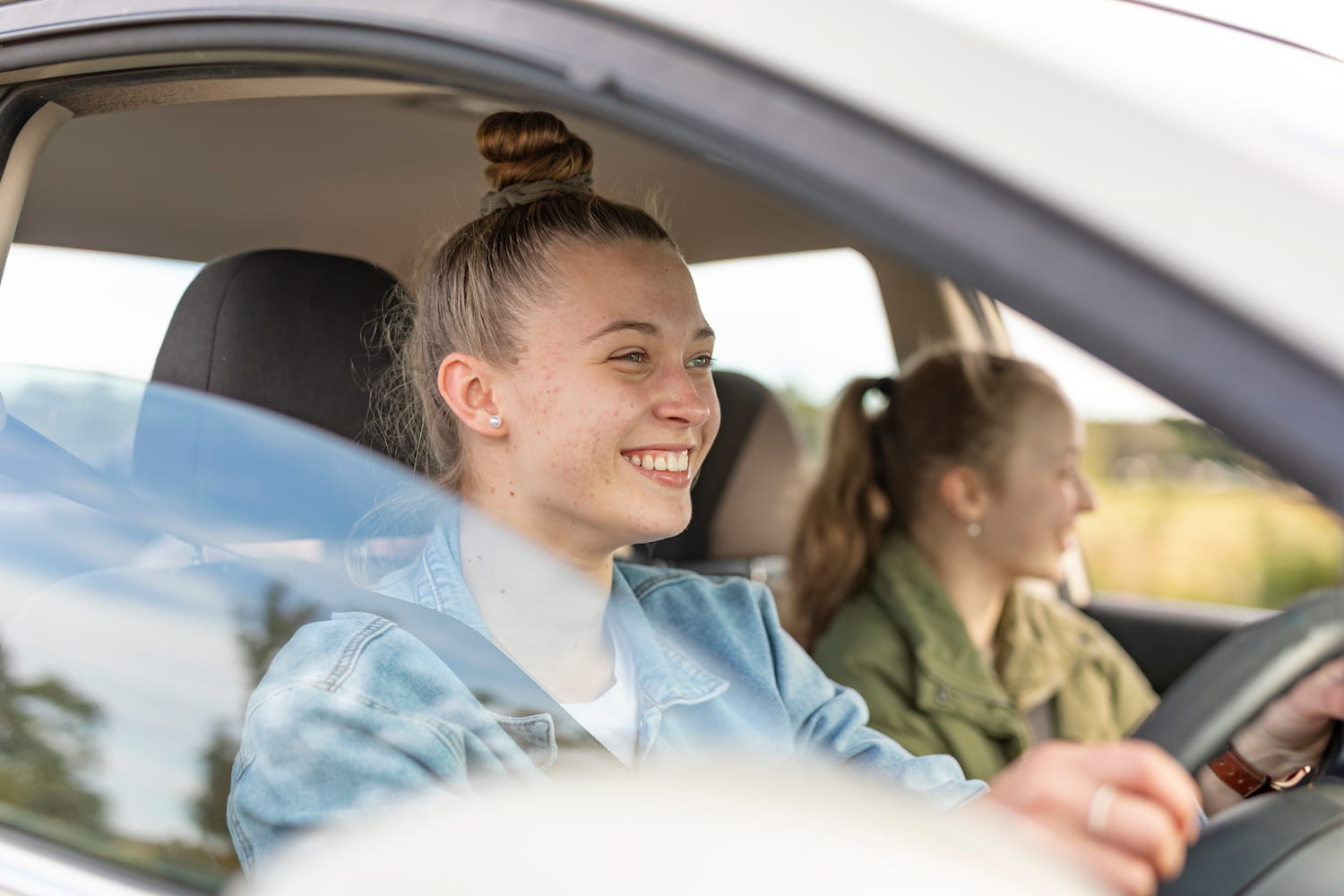 A Young Woman Driving A Friend in Her First Car