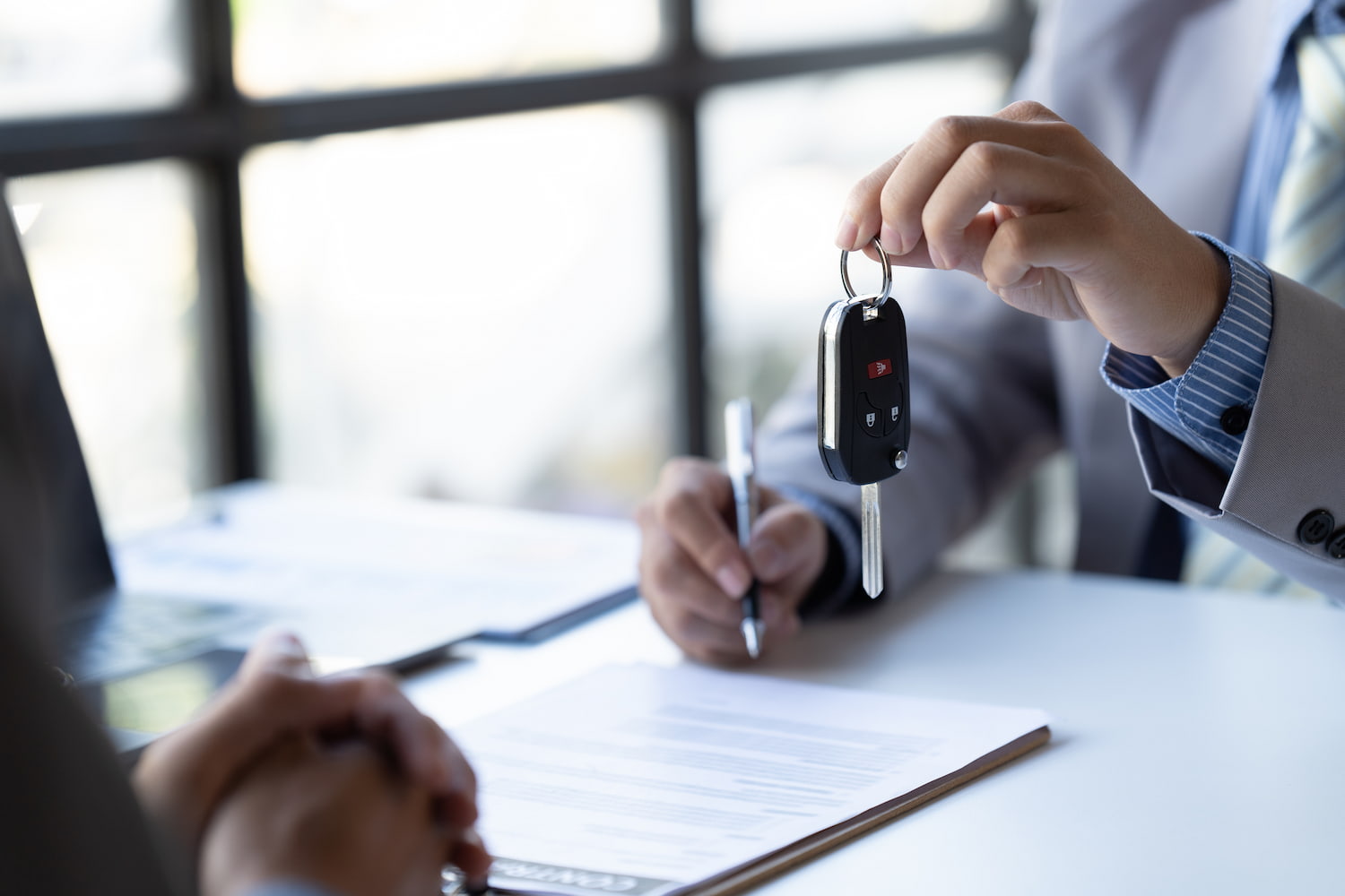 A person handed over the keys to another who finalized a contract.