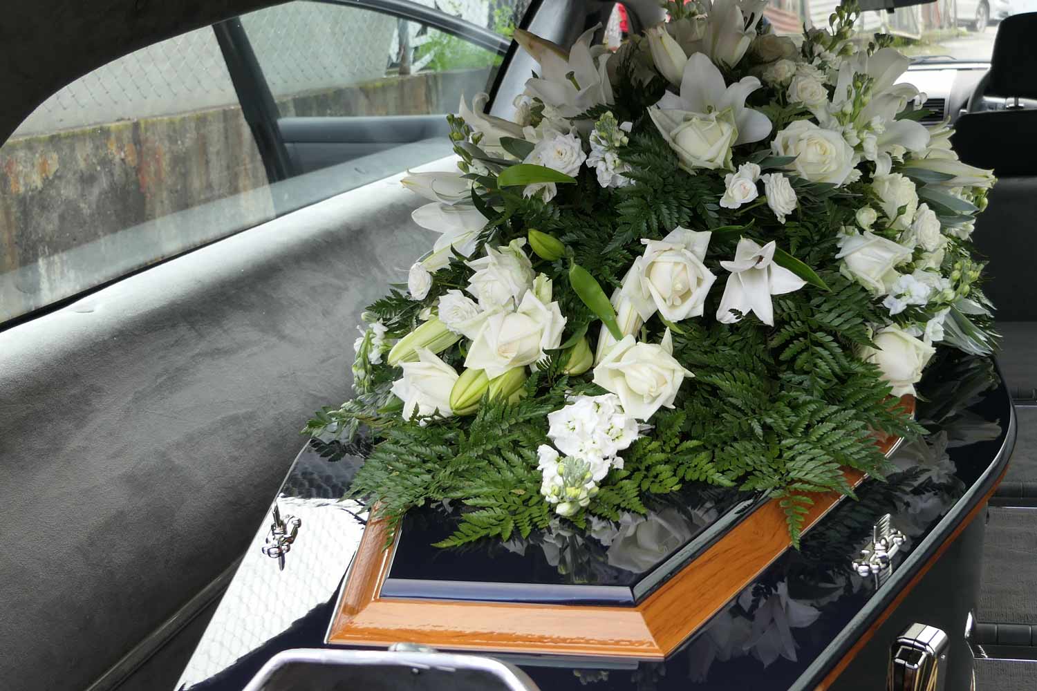 Closeup shot of a funeral casket in a hearse or chapel.