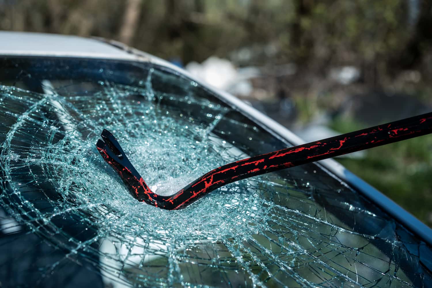 An image showing car glass being broken, specifically focusing on the windshield.