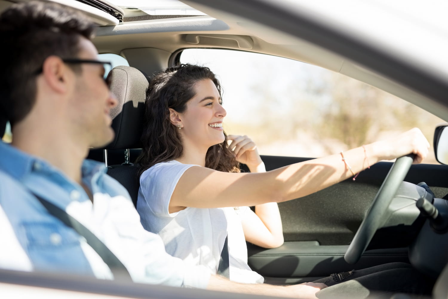 Young happy couple driving in their car.