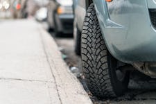 Close-up of a parked car with the tire turned into the curb.