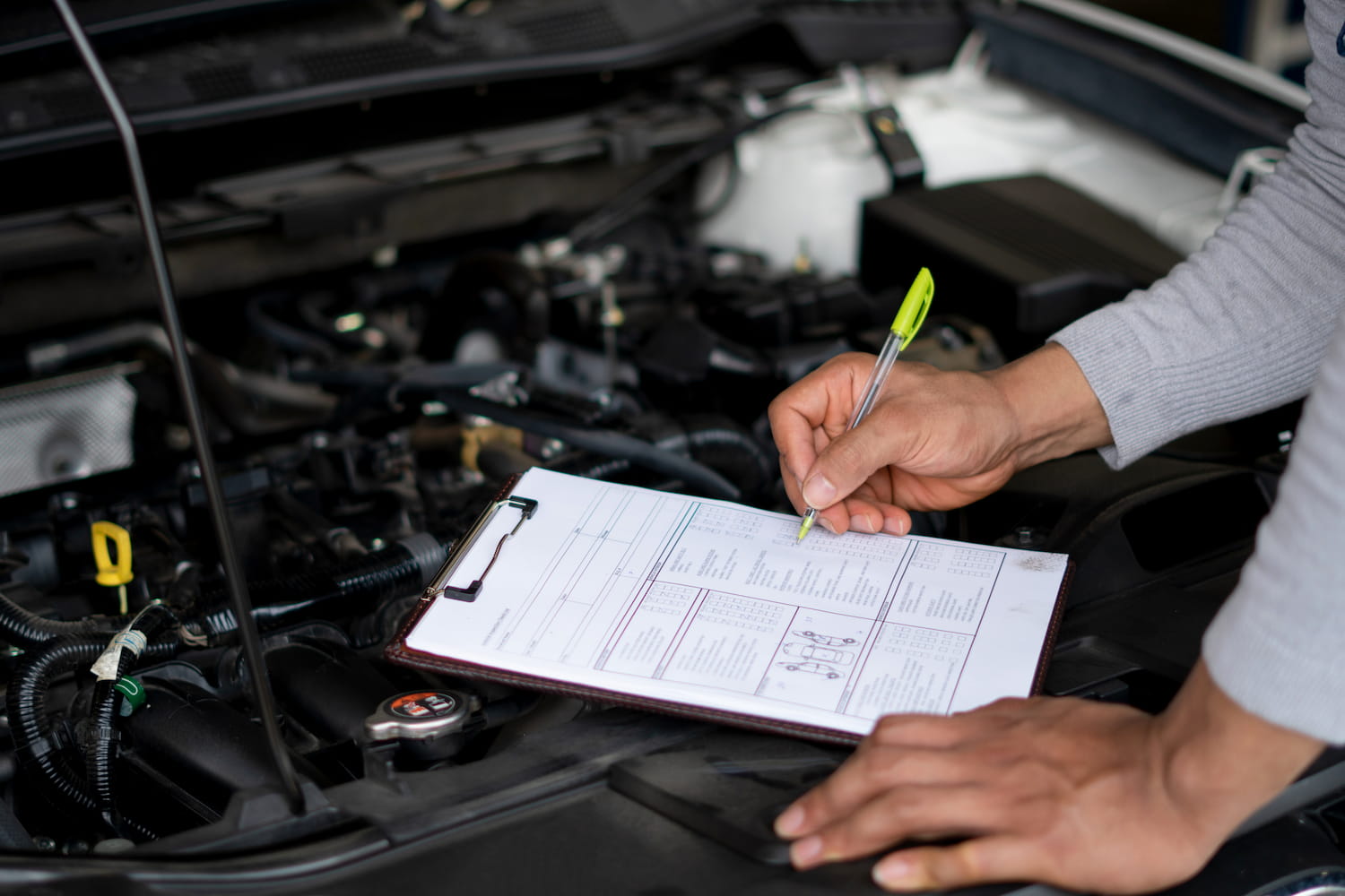 Mechanic checking car engine at the garage.