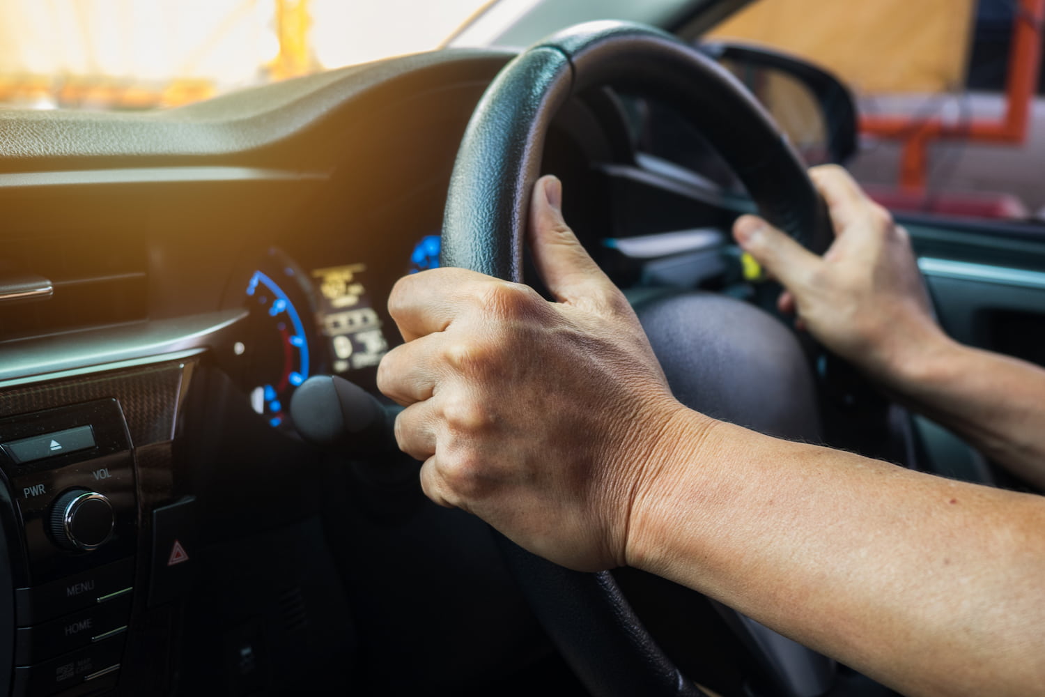 Driver's hands holding the steering wheel during travel.