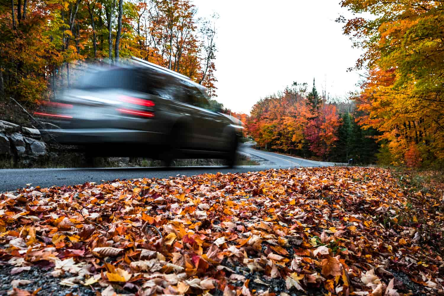 Electric car speeding past in a fall environment