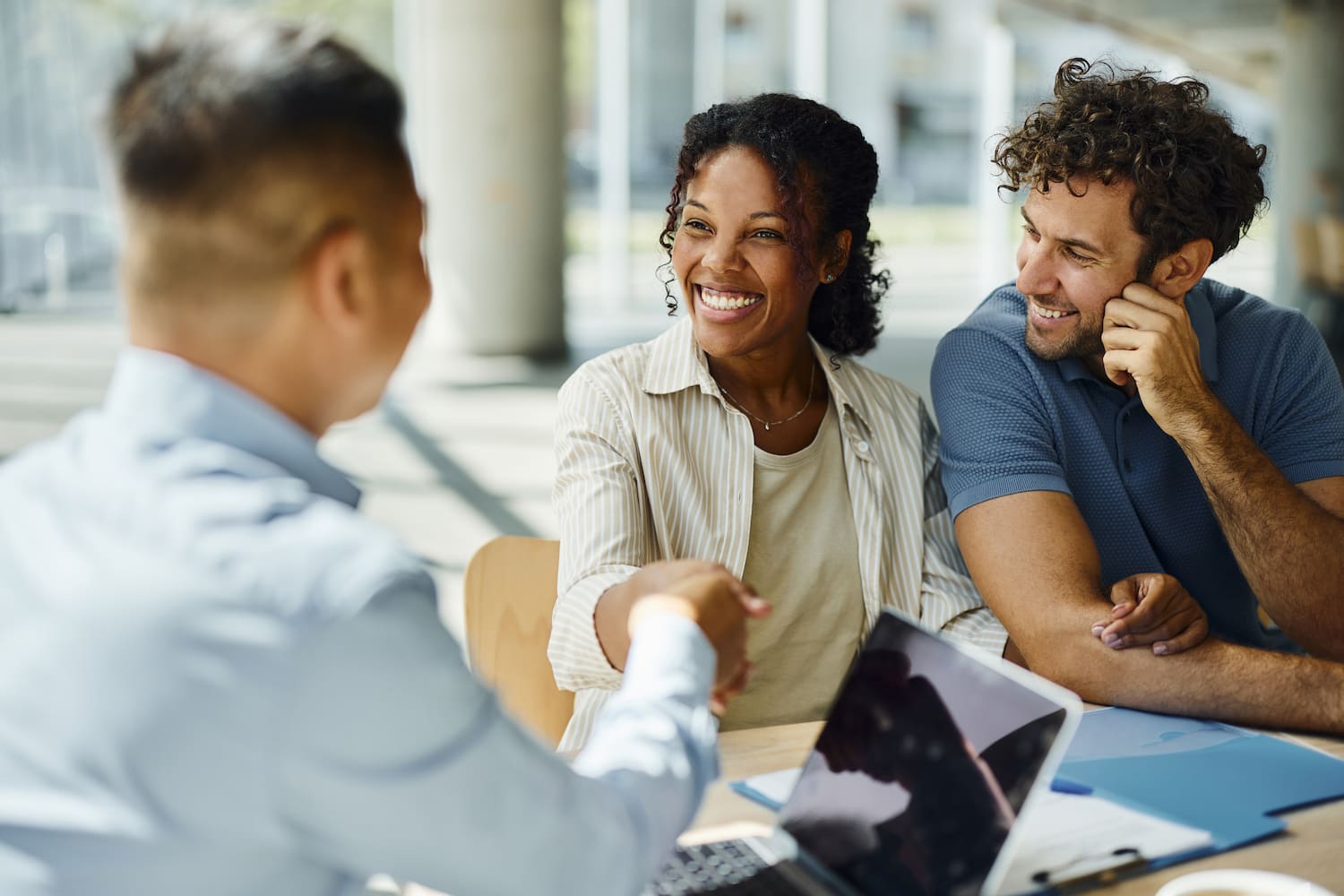 Happy couple reaching an agreement with their agent during an office meeting.