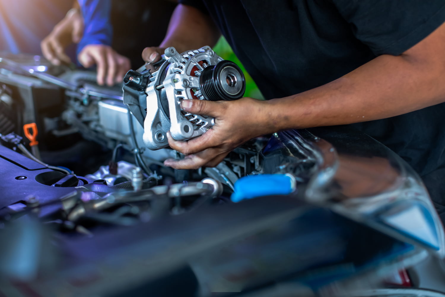 Mechanic holding alternator of the car in repair and maintenance garage.