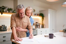 Mature Couple Reviewing And Signing Paperwork