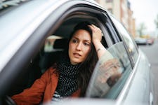 Young commuter woman driving and looking worried