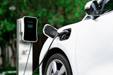 Focus closeup of electric vehicle plugged in with EV charger