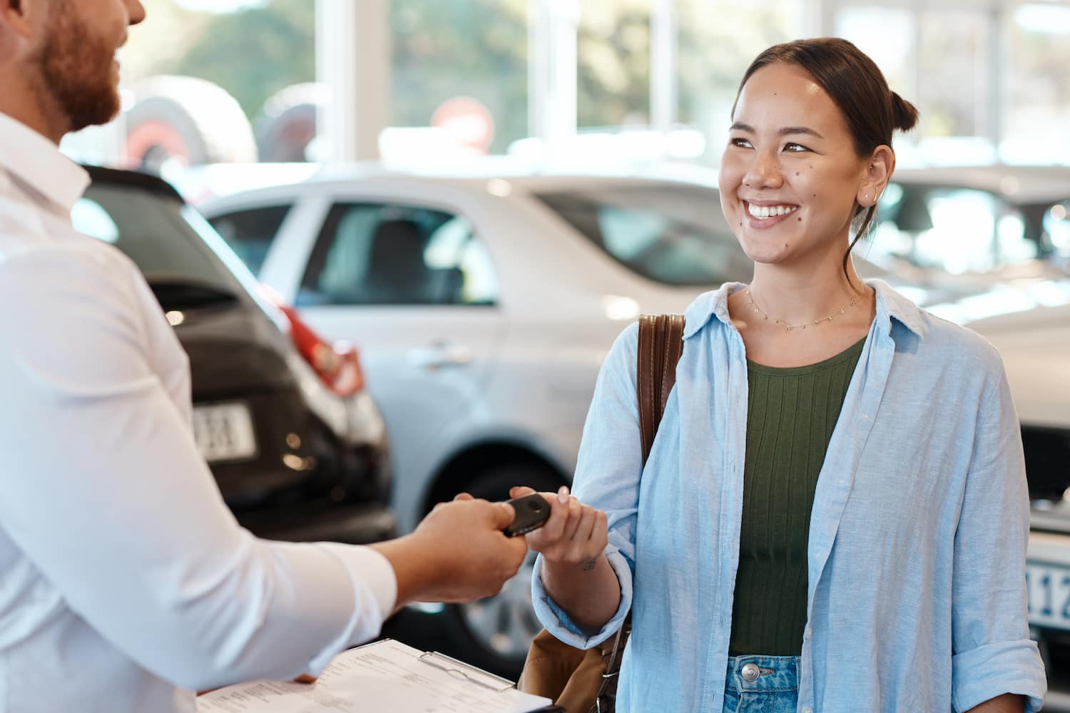 A person handing car keys to another.