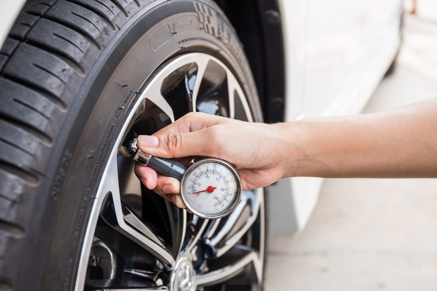 Close-Up of hand holding pressure gauge for car tire