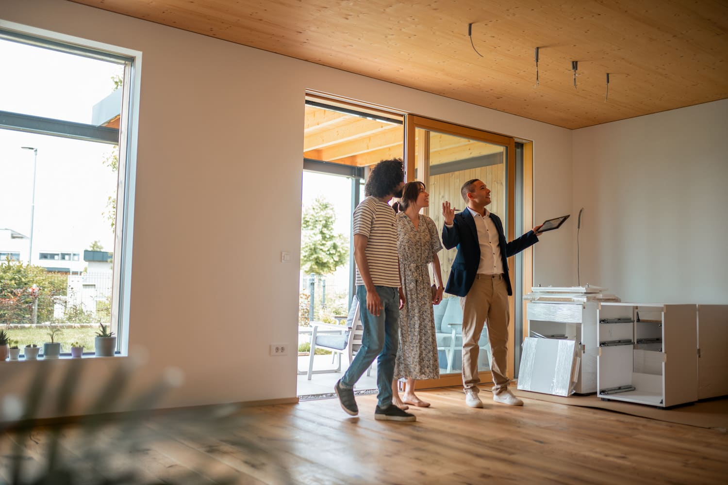 Open house scene with an agent and couple in a bright interior.