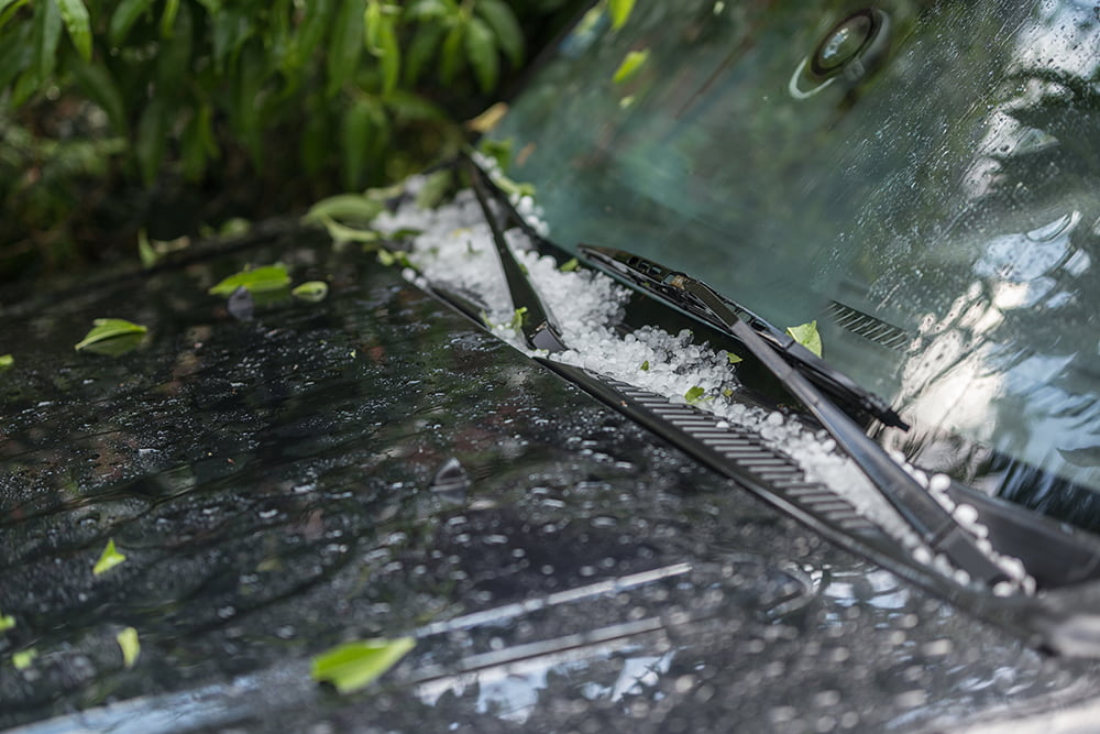 Close up of a car windshield covered in hail