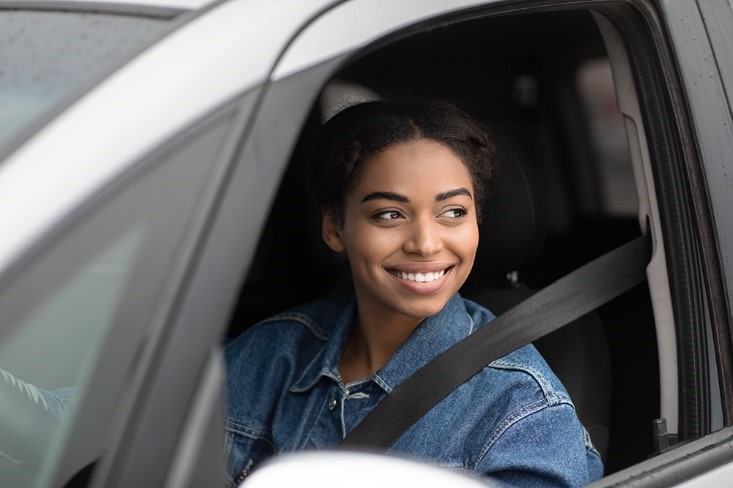 A person sitting in the passenger seat, smiling.