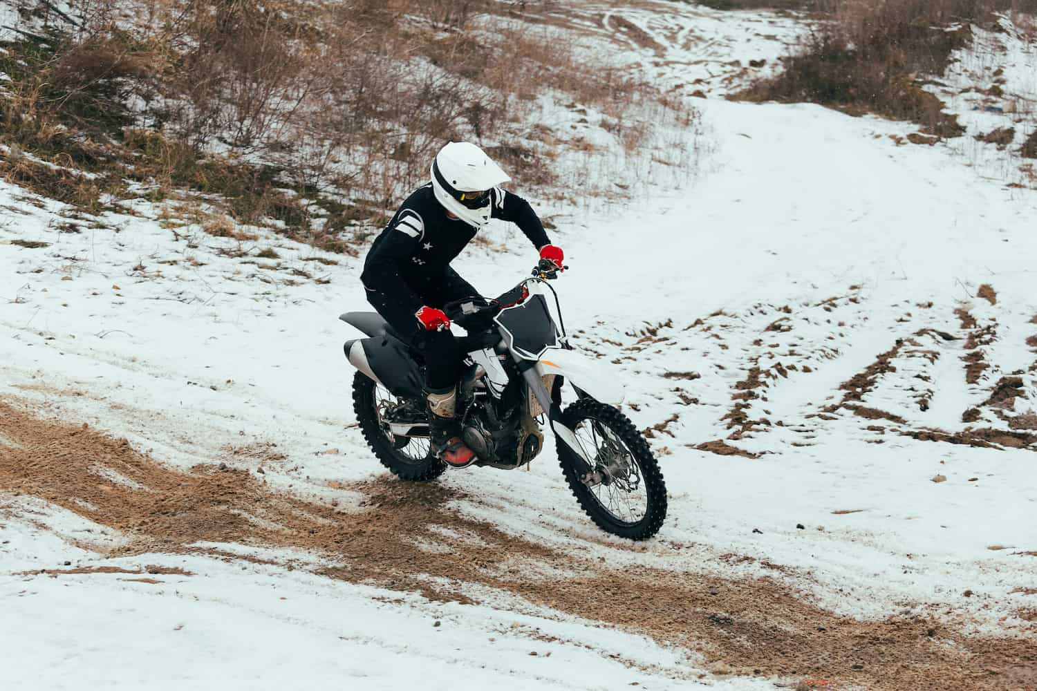 A person riding a motorcycle on a snowy road.