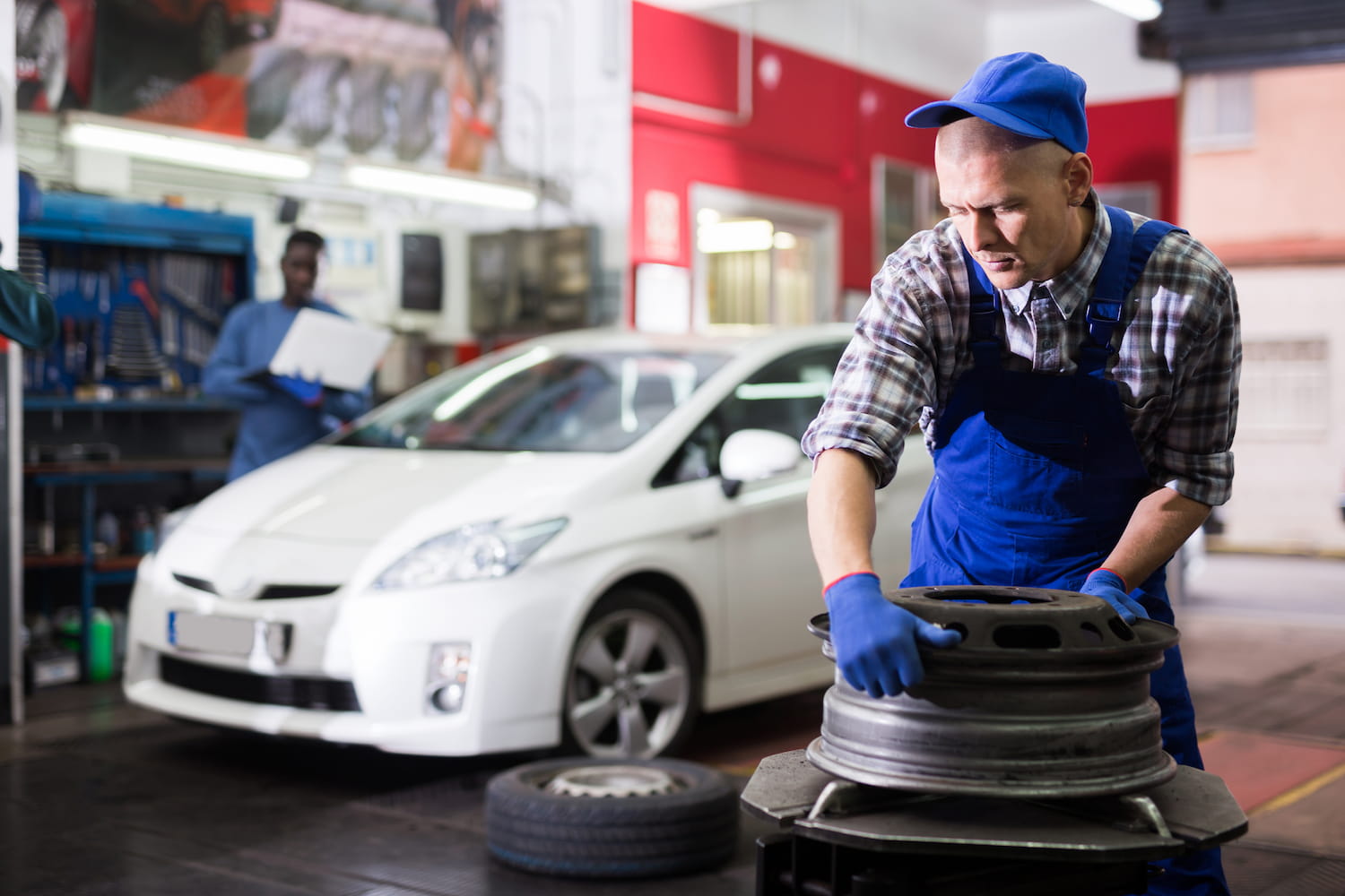 Mechanics performing tire maintenance in a shop.