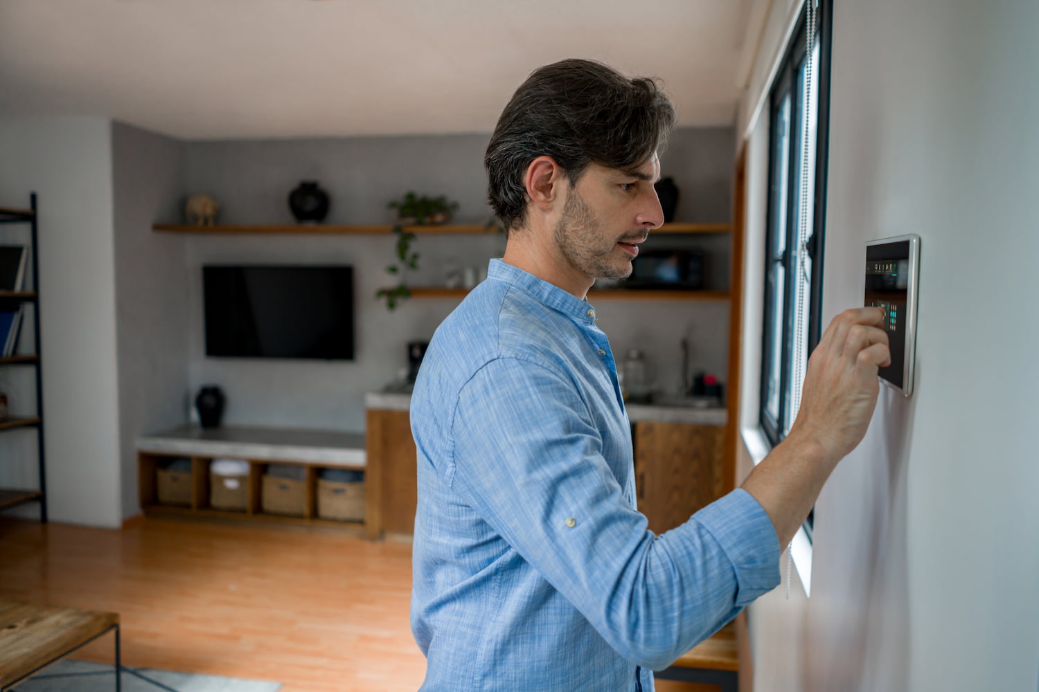 A man locking the door of a house using a home automation system.