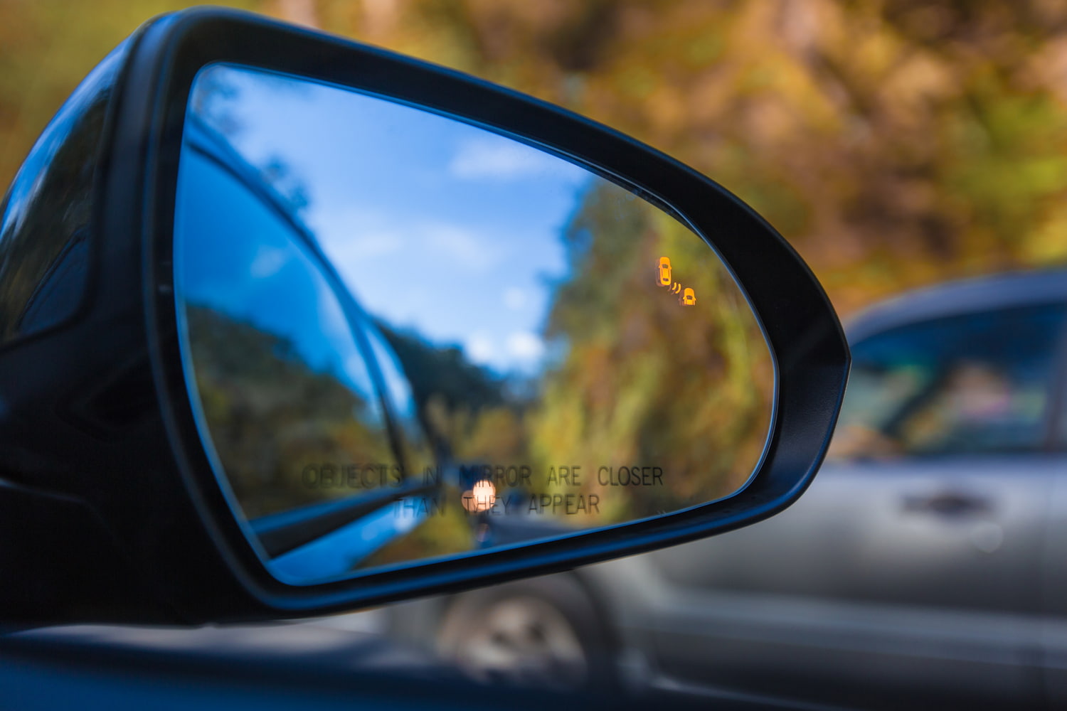 Objects in mirror are closer than they appear with Blind Spot Assist Warning Light.