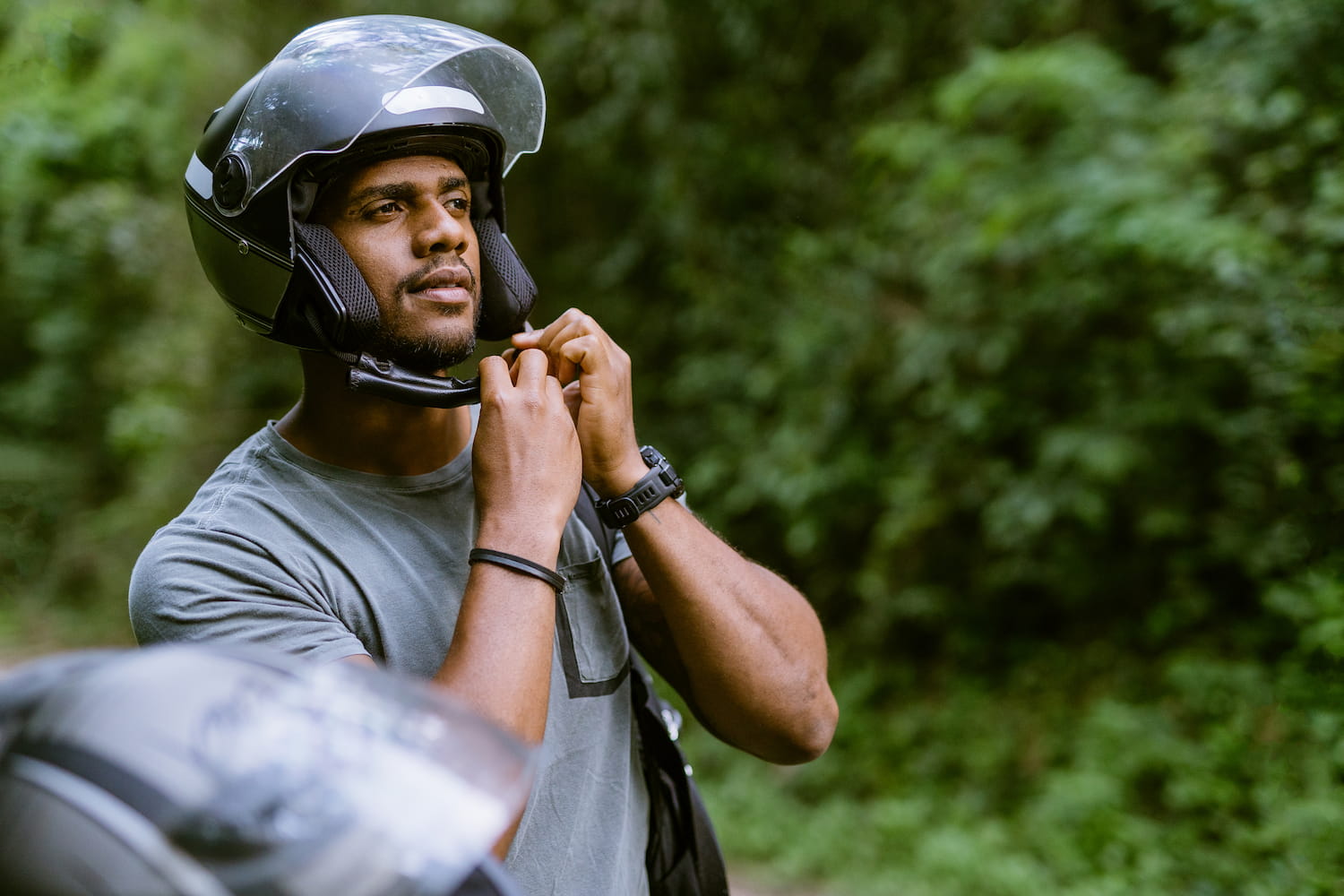 A biker adjusting his helmet