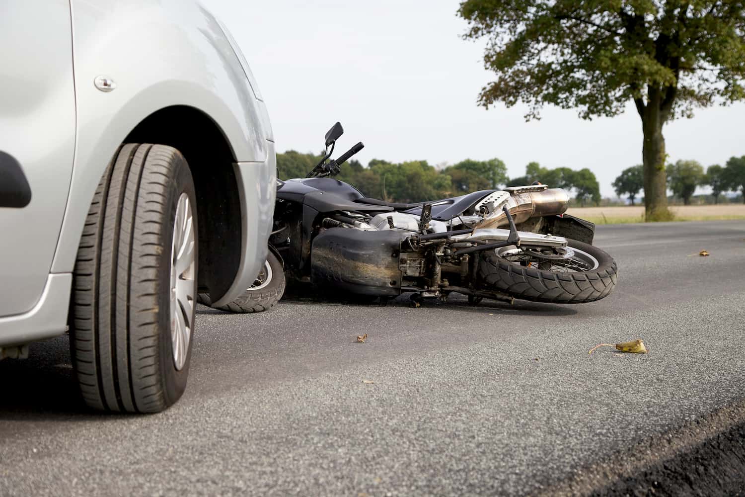 Ground-view of a motorbike accident on the road with a white car