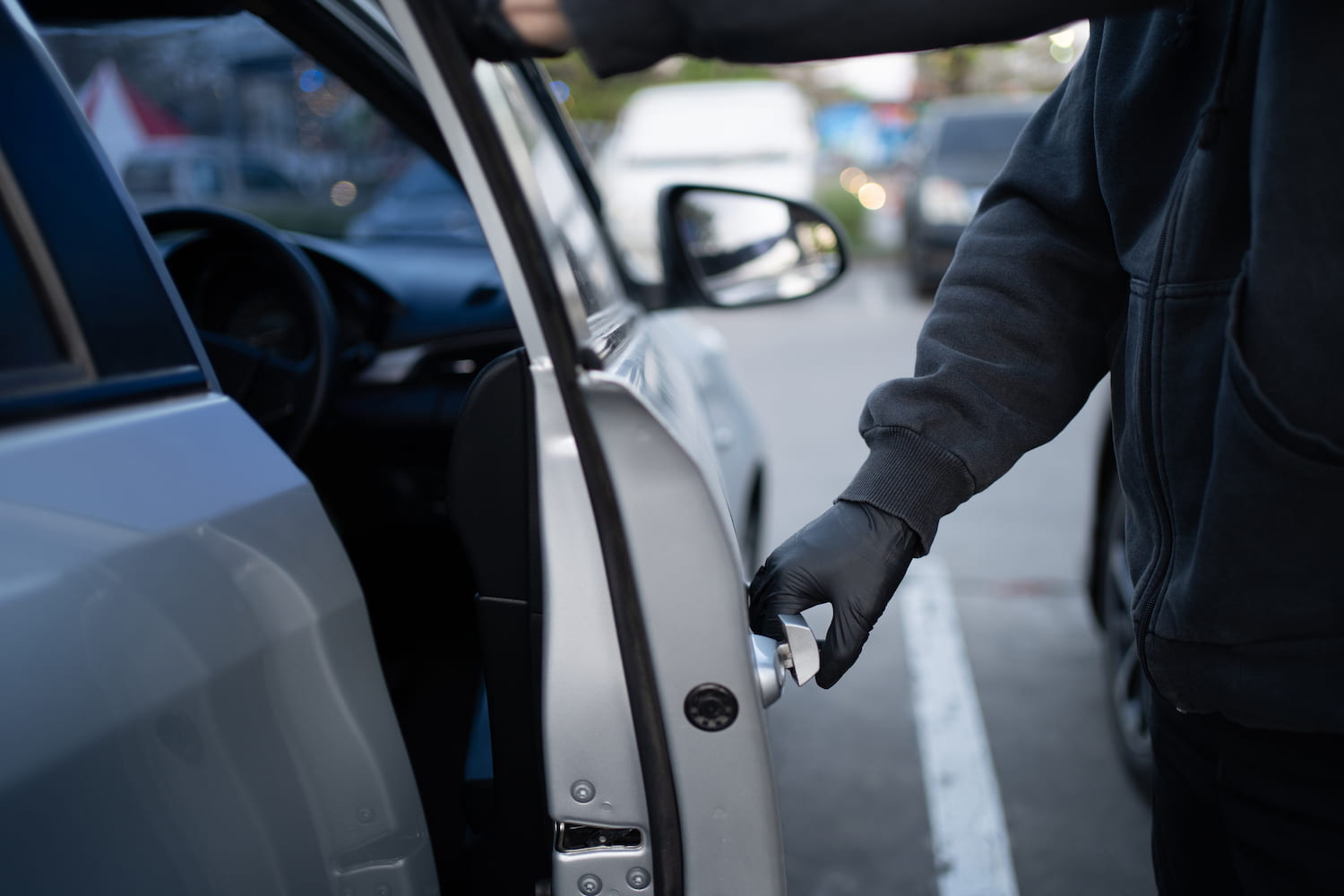 Close-up of a person attempting to break into a car.