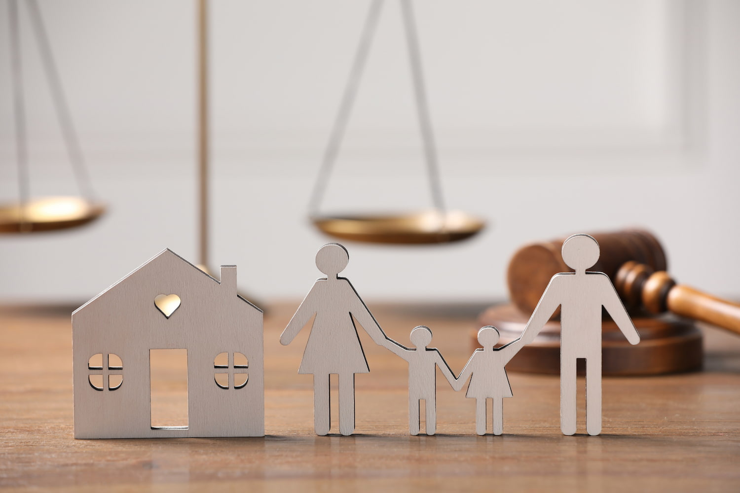 Figures with a house model and legal symbols displayed on a table.