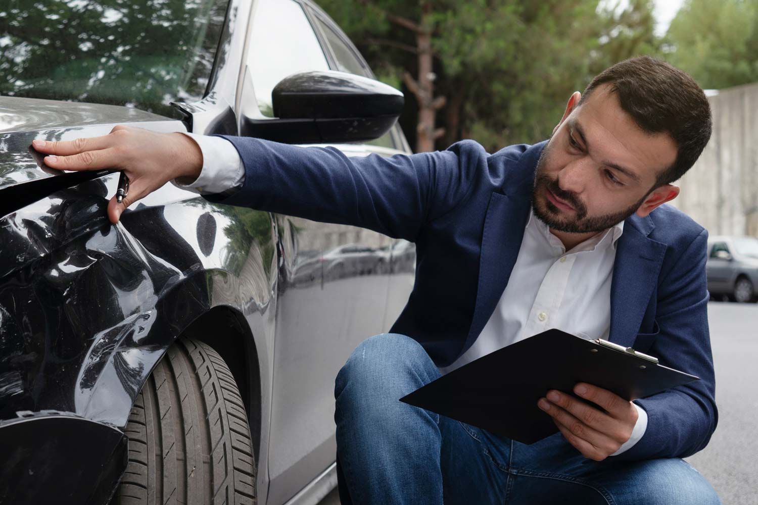 Person inspecting car damage after a crash.