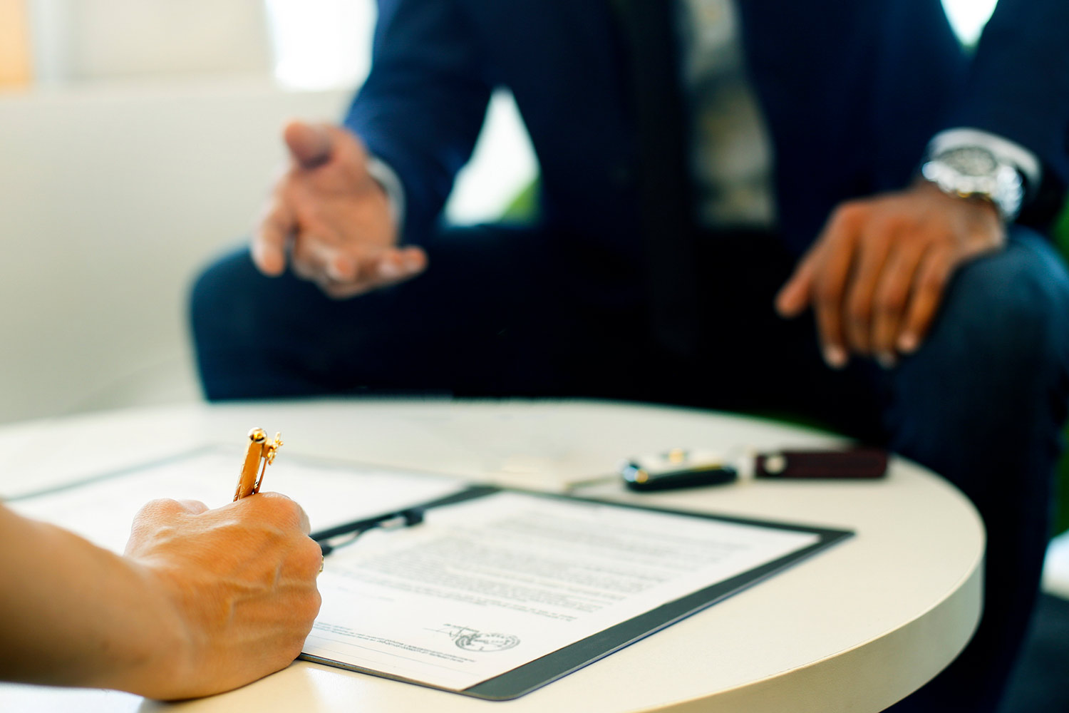 Woman signing car insurance renewal form.