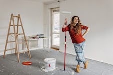 Young woman painting a room.