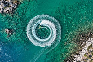 Aerial view of man driving a personal watercraft in the ocean creating a straight down circular pattern