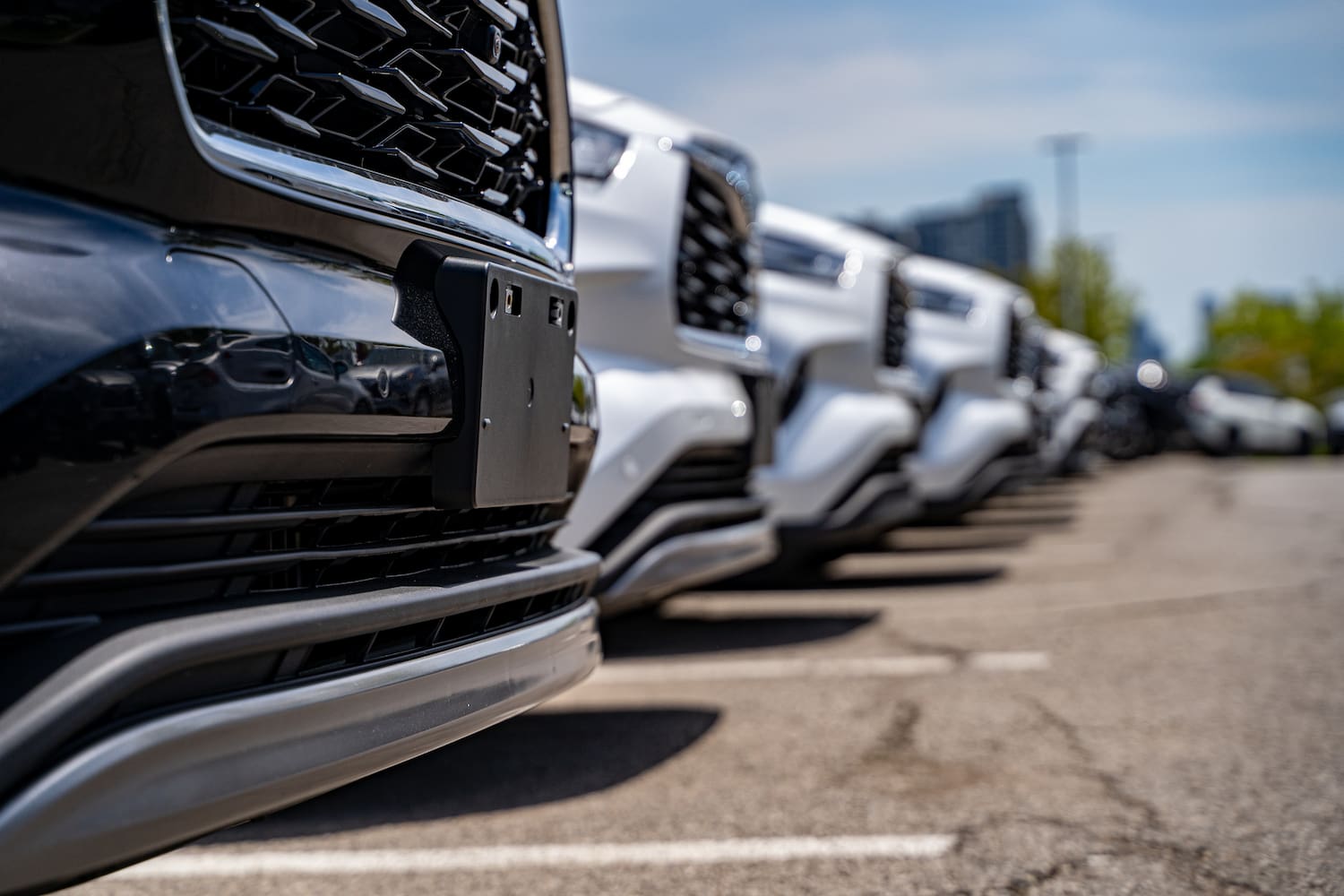 Close up of parked SUVs at car dealership lot.