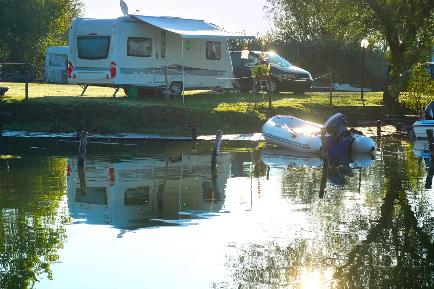 A trailer and a water raft by a lake on a sunny day