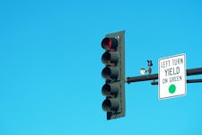 Red traffic light and "left turn yield on green" sign