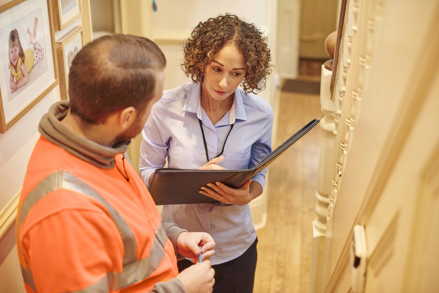 An installer demonstrating a completed alarm system to a housing officer.