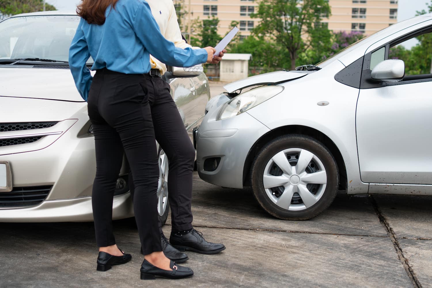 Two Drivers using a smartphone to exchange information after a car accident