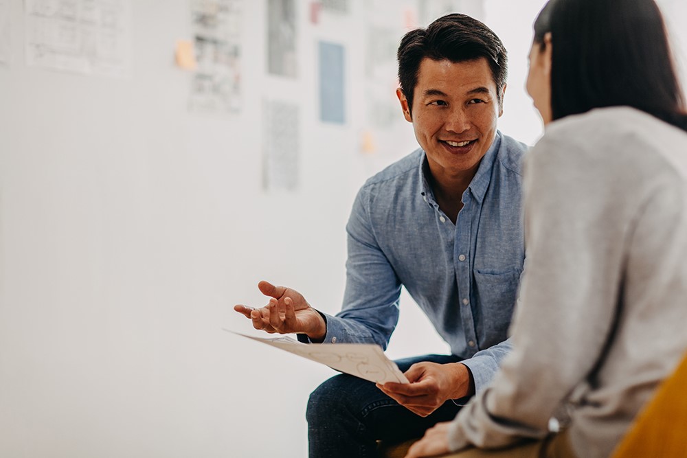 Two people sitting and joyfully engaging in a conversation.