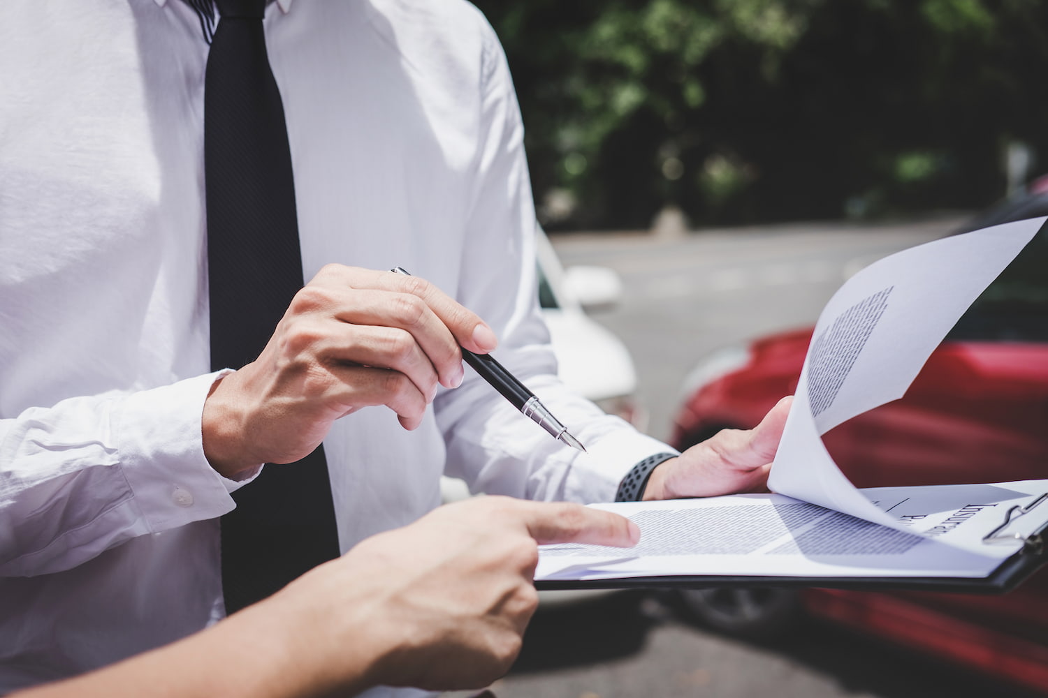 Insurance representative preparing documentation for a vehicle accident claim procedure.