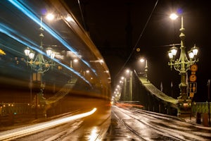 A blurred fast tram at night crossing the street